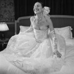 Vivienne Westwood Instagram - The Eline gown offers an unwavering sense of romanticism, embroidered with a Flora motif, taken from an archival couture lace. ⁠
⁠
The dress features a voluminous skirt with panniers, along with a straight neckline and transparent boned low hip corset bodice, accentuating the waistline. ⁠
⁠
The look is styled with fingerless gloves, echoing the decorative  detail of the dress. ⁠
⁠
Photography by @kingsley_ifill⁠
Styling by @florahuddart⁠
Talent: @elinehoyois⁠
⁠
#VWBridal #WestwoodBridal
