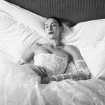Vivienne Westwood Instagram – The Eline gown offers an unwavering sense of romanticism, embroidered with a Flora motif, taken from an archival couture lace. ⁠
⁠
The dress features a voluminous skirt with panniers, along with a straight neckline and transparent boned low hip corset bodice, accentuating the waistline. ⁠
⁠
The look is styled with fingerless gloves, echoing the decorative  detail of the dress. ⁠
⁠
Photography by @kingsley_ifill⁠
Styling by @florahuddart⁠
Talent: @elinehoyois⁠
⁠
#VWBridal #WestwoodBridal