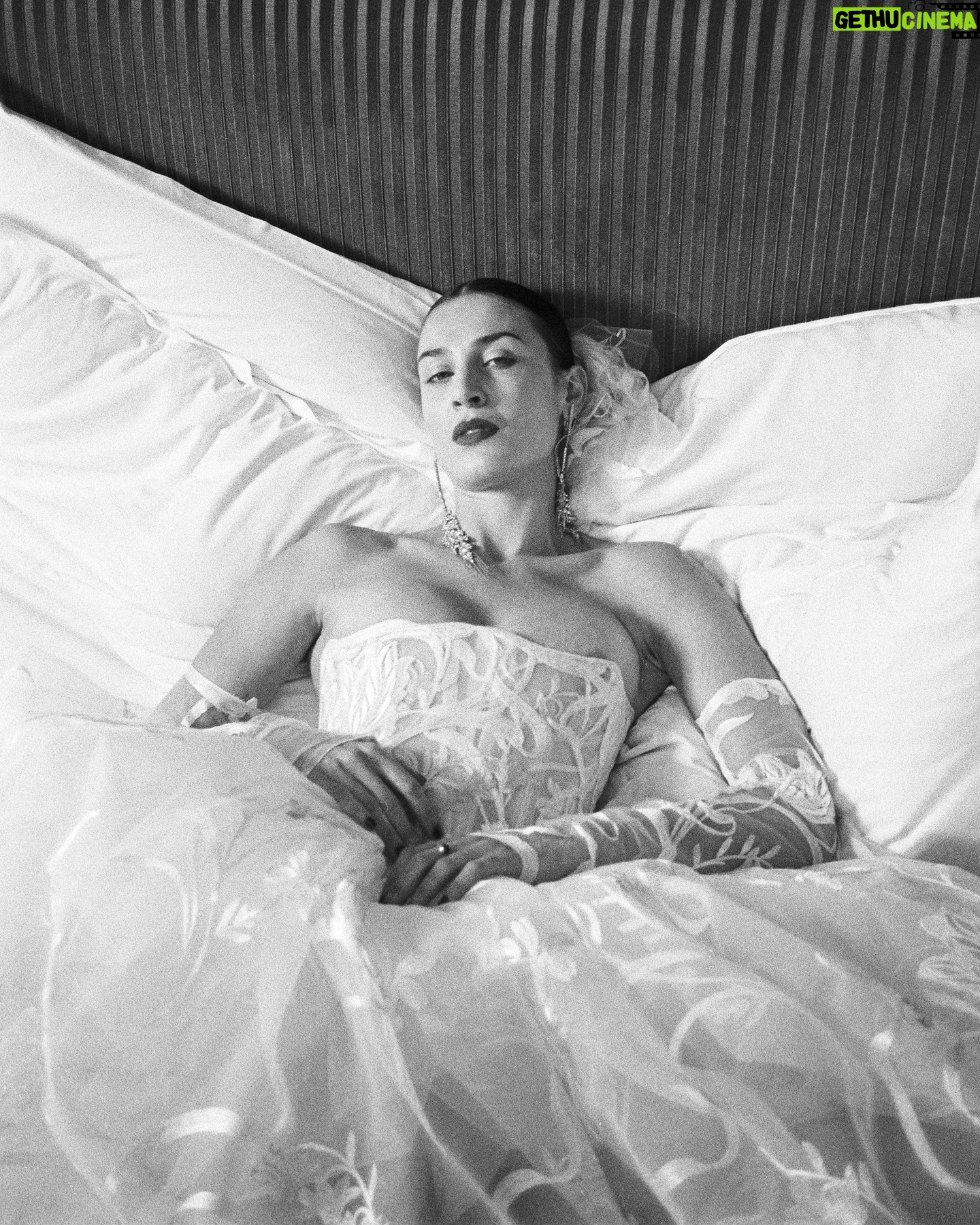 Vivienne Westwood Instagram - The Eline gown offers an unwavering sense of romanticism, embroidered with a Flora motif, taken from an archival couture lace.
The dress features a voluminous skirt with panniers, along with a straight neckline and transparent boned low hip corset bodice, accentuating the waistline.
The look is styled with fingerless gloves, echoing the decorative detail of the dress.
Photography by @kingsley_ifill
Styling by @florahuddart
Talent: @elinehoyois
#VWBridal #WestwoodBridal