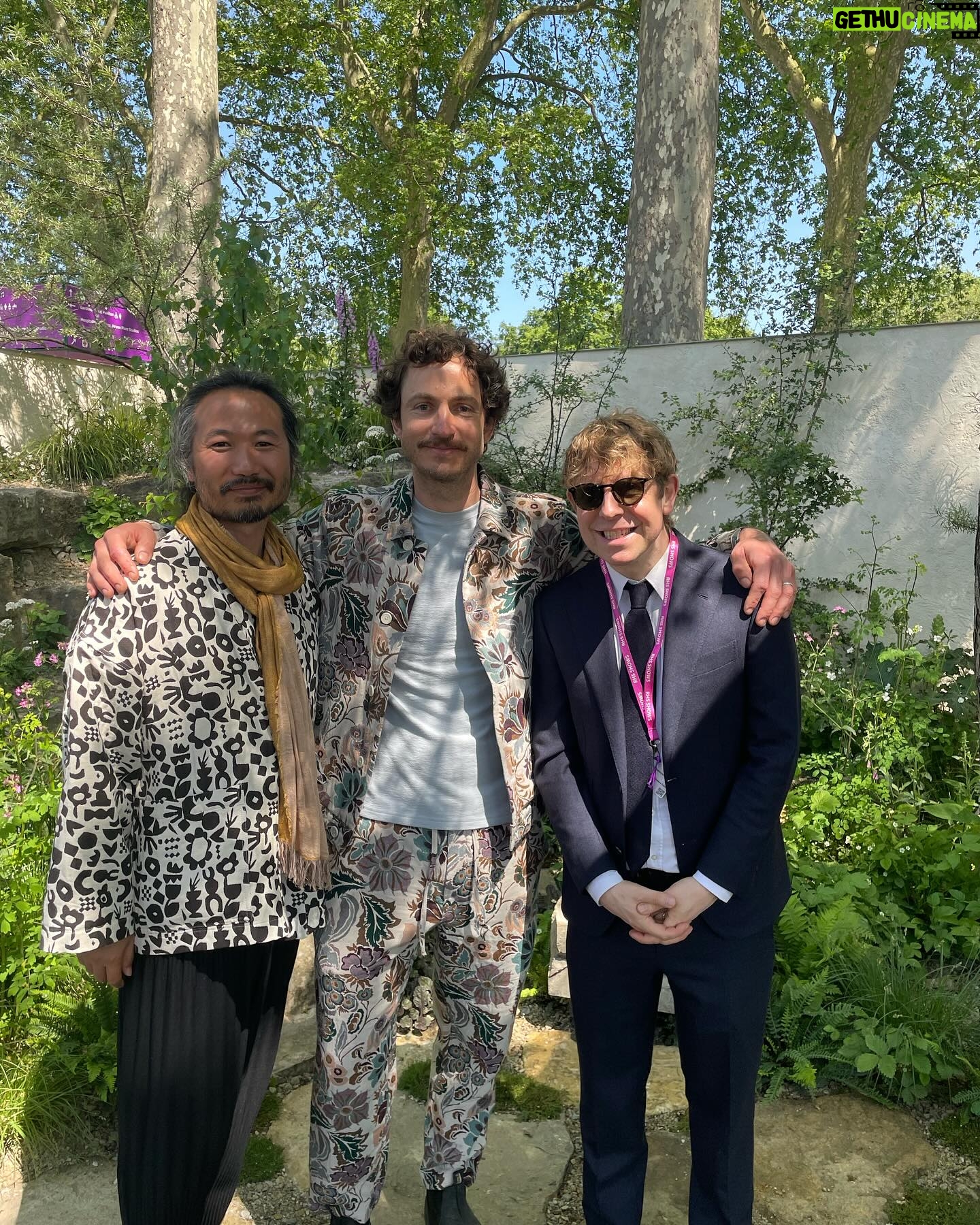 Aisling Bea Instagram - Avoided drawing attention to myself today @the_rhs Chelsea Flower show, if you zoom in, you will be able to make me out. I LOVE power plants & BIG bushes & there were so many on display today. But my favourite garden was my friend @tommasseyuk ‘s one for @wateraid which he co-designed with Je @studioweave - both seen here with @josh_widdicombe who did not get the “dress like a flower”memo. The garden features flowers and plants which are resilient to extremes in weather, especially rainfall, which is more important than ever with our changing climate. Also some flowers which may be not deemed as fancy and pretty as others, which breaks my hear as they are ALL loveable. Almost one in ten people around the world don’t have access to clean water close to home, and the climate crisis is making it worse. So the mushroom like design is a rainwater-harvesting pavilion inspired by WaterAid’s work in communities around the world. “But tell us about your outfit so we too can completely cover up in the sun!” Well, I tried to wear an eco outfit today featuring a gorgeous but ill advised in the sun jumper from small brand @theslowlove , a flowery dress from @reformation who make their clothes from leftover material, jewellery & a handbag which fits everything from a variety of charity shops & some earth day shoes from eco brand @vivaia_official who make their shoes from recycled materials and try to reduce waste in their factories. Bought everything so you can TRUST ME. Thanks to @thenewtinsomerset & @the_ivy_collection for feeding myself, my brother in law @mkidao & auntie in law - we are stuffed and covered in pollen. And thank you to @lordham for making sure my hair was nice and shiny. xxx