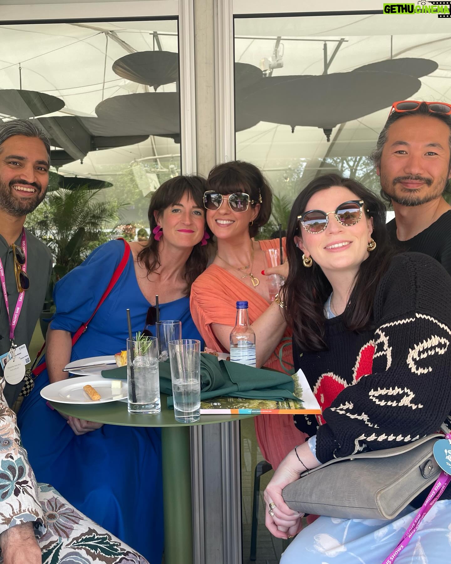 Aisling Bea Instagram - Avoided drawing attention to myself today @the_rhs Chelsea Flower show, if you zoom in, you will be able to make me out. I LOVE power plants & BIG bushes & there were so many on display today. But my favourite garden was my friend @tommasseyuk ‘s one for @wateraid which he co-designed with Je @studioweave - both seen here with @josh_widdicombe who did not get the “dress like a flower”memo. The garden features flowers and plants which are resilient to extremes in weather, especially rainfall, which is more important than ever with our changing climate. Also some flowers which may be not deemed as fancy and pretty as others, which breaks my hear as they are ALL loveable. Almost one in ten people around the world don’t have access to clean water close to home, and the climate crisis is making it worse. So the mushroom like design is a rainwater-harvesting pavilion inspired by WaterAid’s work in communities around the world. “But tell us about your outfit so we too can completely cover up in the sun!” Well, I tried to wear an eco outfit today featuring a gorgeous but ill advised in the sun jumper from small brand @theslowlove , a flowery dress from @reformation who make their clothes from leftover material, jewellery & a handbag which fits everything from a variety of charity shops & some earth day shoes from eco brand @vivaia_official who make their shoes from recycled materials and try to reduce waste in their factories. Bought everything so you can TRUST ME. Thanks to @thenewtinsomerset & @the_ivy_collection for feeding myself, my brother in law @mkidao & auntie in law - we are stuffed and covered in pollen. And thank you to @lordham for making sure my hair was nice and shiny. xxx