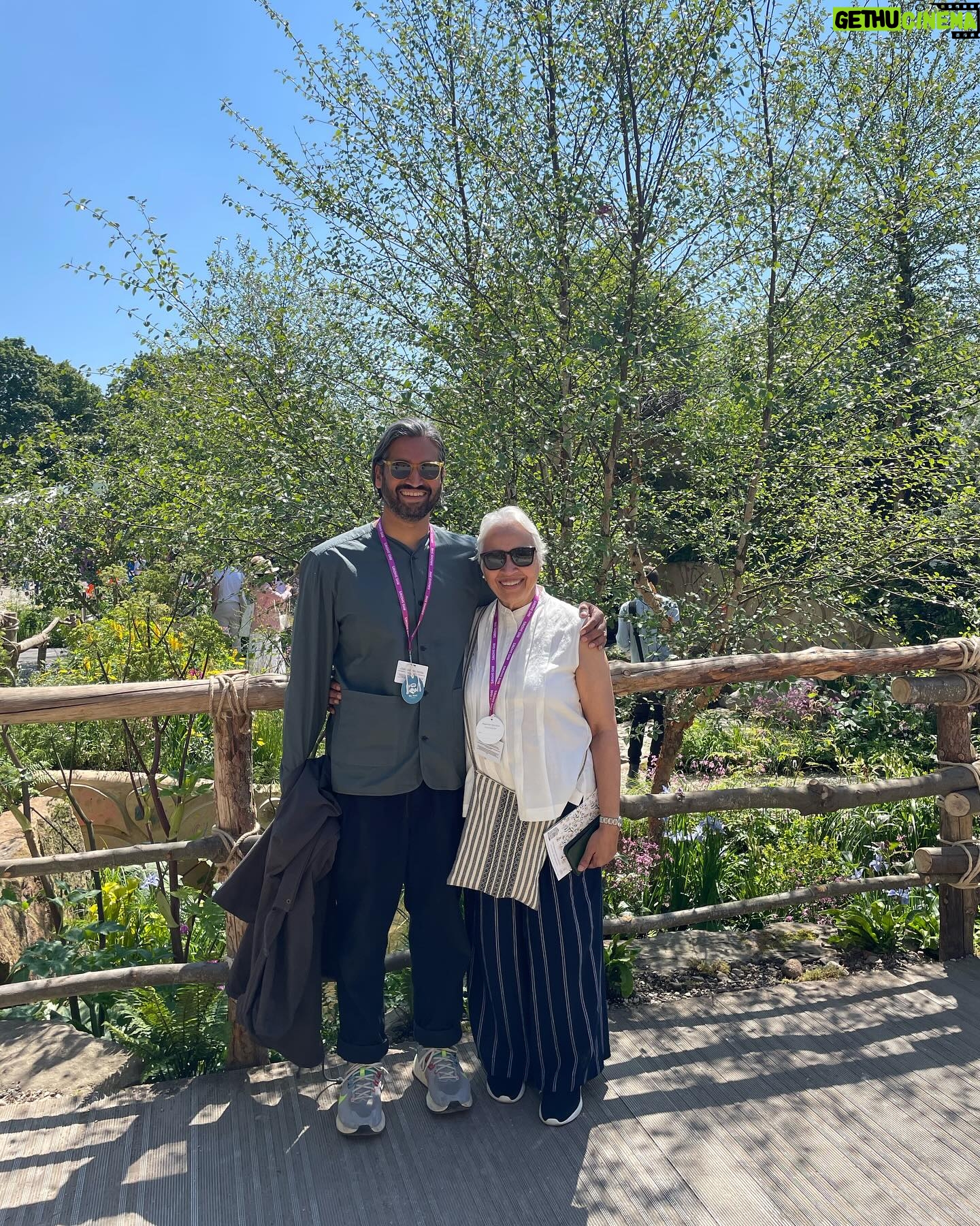 Aisling Bea Instagram - Avoided drawing attention to myself today @the_rhs Chelsea Flower show, if you zoom in, you will be able to make me out. I LOVE power plants & BIG bushes & there were so many on display today. But my favourite garden was my friend @tommasseyuk ‘s one for @wateraid which he co-designed with Je @studioweave - both seen here with @josh_widdicombe who did not get the “dress like a flower”memo. The garden features flowers and plants which are resilient to extremes in weather, especially rainfall, which is more important than ever with our changing climate. Also some flowers which may be not deemed as fancy and pretty as others, which breaks my hear as they are ALL loveable. Almost one in ten people around the world don’t have access to clean water close to home, and the climate crisis is making it worse. So the mushroom like design is a rainwater-harvesting pavilion inspired by WaterAid’s work in communities around the world. “But tell us about your outfit so we too can completely cover up in the sun!” Well, I tried to wear an eco outfit today featuring a gorgeous but ill advised in the sun jumper from small brand @theslowlove , a flowery dress from @reformation who make their clothes from leftover material, jewellery & a handbag which fits everything from a variety of charity shops & some earth day shoes from eco brand @vivaia_official who make their shoes from recycled materials and try to reduce waste in their factories. Bought everything so you can TRUST ME. Thanks to @thenewtinsomerset & @the_ivy_collection for feeding myself, my brother in law @mkidao & auntie in law - we are stuffed and covered in pollen. And thank you to @lordham for making sure my hair was nice and shiny. xxx