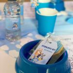 Amy Hart Instagram - This Episode Of Bluey Is Called Stanley’s First Birthday 🎂 💙🩵 The best time for my little boys first birthday 🎁 Theme:I looked on Pinterest and sent @everylastdetail_x a reeeally long voice note and as always they delivered!!! Even down to themed waters, biscuits from @thecupcakecollectionx , dog bowls instead of plates and little bone name tags 🥲. Roll on my UK hen do!! Food: I got pizzas for the adults, lots of different cans of drink and my Nan brought some cupcakes 🤣 For the babies I just went online and ordered so so many @kiddyliciousuk snacks. Felt this was the best zero waste option as now our cupboard is stocked with the ones we didn’t use!! My mum also did a tray of sandwiches and a tray of chicken dippers and sausages. Activities: We used two local family run companies, @rentyoureventsussex for the bluey soft play and DSH Leisure for the bouncy castle. I had DSH castles my whole childhood so really special that we can now use them for Stanley!! We also had @one_stop_partyshop come along with Bluey herself! I tried to book the full 2 hour party but they recommended that we just did 30 mins and it was fab! Games, singing and dancing and a meet and greet! I also used to do panto with Blueys party assistant so it really was the most Worthing party you can get 🤣 Cake: We used @kellyscakes_ We had white chocolate and raspberry (Stanley’s faves) and it was sooo good! Also very reasonably priced and I finally managed to order a cake for the size of the guest list and not for the feeding of the 5000!! Outfit: @indielledesigns 💙 my go to for seasonal clothing! Party Boxes: I had seen adopt a floppy on Pinterest so asked @my1styears if we could do a bulk order of the bunnies, they took it extra and gifted everyone a personalised denim jacket 😢 I also bought a box of bubble wands off Amazon and each child got a little book too! (Little libraries, also from Amazon!) (m1y also gave me a discount code which is AMYHART10 xx)