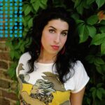 Amy Winehouse Instagram - Amy photographed in 2003, with big red hoop earrings and a rising star in her eyes. 🍃❤️ 'Recognise my every sound; there's nothing new to learn’ 🤍 📸 Eva Vermandel