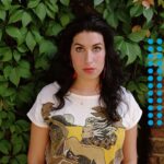 Amy Winehouse Instagram - Amy photographed in 2003, with big red hoop earrings and a rising star in her eyes. 🍃❤️ 'Recognise my every sound; there's nothing new to learn’ 🤍 📸 Eva Vermandel