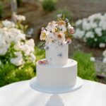 Arielle Vandenberg Instagram - I’ve always dreamed of having an intimate, backyard wedding! And two of our best friends, graciously offered their home! We wanted our wedding to be simple and sweet! And that’s exactly how it was! Bright and delicate flowers sprinkled across the tables. It definitely helped that the entire backyard had white roses in full bloom! (Gods gift saved us thousands of dollars lol). We had a deliciously unique cake that tasted of tres leches and apricot 🤤 (hands down favorite cake I’ve ever had). I’ve always wanted pizza at my wedding, so we hauled a 500 lbs pizza oven into the backyard for fresh amazing pizza! (Should have ate more that night, that’s for sure. 😂) Everyone took home Cutie cookies painted like our favorite girl, Stinky! Love was in the air as the fairy lights above our heads twinkled in the night sky and we danced the night away! ✨ Photos: @christinamcneill Video: @whiteinrevery Coordinator: @carlyraeweddings Dress: @chosenbykyha via @enblanc_la Veil: @amsale Glam: @afton Suit: @paulsmithdesign Catering: @madeinitalybistro Florals: @floretfloral Music: @rickyrocksdrums Cake: @kellygraycakes Cookies: @cubandcuppy Rentals: @lapinataparty Venue: @thejasonkennedy @thelaurenkennedy backyard 😍