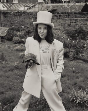 Bella Ramsey Instagram - Books are supposed to go on heads and Bella’s are supposed to go on postboxes and glasses are supposed to go on books on heads and then there’s a tortoise. Thank you Vanity Fair and friends. 🐢🙆🏻🎩📚🕶️