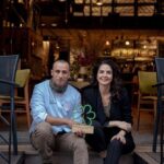 İclal Aydın Instagram - 2018 yılında Urla’ya yerleşmiştim. Bir yılı aşkın bir süre @gazete.oksijen ‘den Urla’nın doğa- tarih dostlarını, yemek ve şarap üreticilerini,mimari ve edebi eserlerini, insanların hikayelerini anlattım. Bu hikayelerin ilki @urlavinolocale ‘in kurucuları @seraysenkumbasar ve @kumbasaro idi. İki genç gece gündüz büyük bir inançla ve elleriyle bir köy arazisi üzerinde bir bina inşa etmişlerdi. Onları tanıdıkça çok sevdim, emeklerine, inançlarına hayran oldum. Tanışıklığımız kardeşliğe döndü. 🌸 Sonra @teruarurla doğdu. Sevgili @osmserdaroglu ve @ezgserdaroglu ‘nun aşkla büyüttüğü Urla incisinin hikayesini yazarken “Bir filmin içinden geçer gibi yaşadığımı” düşünmüştüm. Sonra @hicurla ailesi ve sevgili @duyguozersonelakdar Muazzam bir yatırım, ekip ve azim hikayesi onlarınki de. Zeytin ormanlarındaki zeytin,zeytinyağı fabrikasından çıkan yağ, arazilerindeki binbir şifalı otlarla hazırlanan yemekler, tarihi bir binadan dönüştürdükleri restoranlarında, kendi üretimleri seramik tabaklarda ulaşır müşterisine. Her adımı bir başka muhteşem yola çıkar. Sonra bir diğer komşum @levanurla . Bahçesindeki nar ağaçları altında dünyanın en güzel bulut çikolatasını yediğim, güleryüzlü Onur.. Sonra hepimizin @handankaygusuzer ablası var. Buradaki gastronomi zenginliğinin ilk durağı @begendikabi_urla Köylüyü enginar ekmeye ikna eden müthiş kadın. Ve tabii ki @odurla. @osmanaezener ve ailesinin İzmir’e katkıları zaten bütün ülke tarafından alkışlanıyor. Bu komşularımın hepsi bu hafta Michelin tarafından onurlandırıldı. Ozan şefim biri yeşil biri kırmızı iki yıldız aldı. Osman şefim bir yıldızla ödüllendirilirken Hiç bir yeşil yıldızı göğsüne taktı. Levan ve Beğendik abi tavsiye listesine girdiler. Odurla da iki yıldızla gururlandıranlardan… Bu sabah boğaz ağrısıyla uyandım. Dünyanın alkışladığı bu isimler benim komşumdu bir vakitler. Bir bakardımki kapımda Ozan şefin yaptığı çorba duruyor😍 Hepsinin ilk hikayelerini @gazeteoksijen ‘de okuyabilirsiniz. Bitirmeden… Sevgili Seray. Cumhuriyetimizin 100.yılında aldığın bu sommelier yıldızı ile (eğitimli ve bilgili bir şarap uzmanı ve dünyada bir ilk) o geceye ve bu yıla bir kadın damgası vurdun. Helal olsun sana🧿