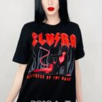 Cassandra Peterson Instagram - Unleash the ultimate goth vibe with your favorite @therealelvira tee! Which one do you rock? 🖤💀 Model: @elisawiitch #kreepsville666 #kreepsville #elvira #gothfashion #graphictees