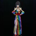 Cassandra Peterson Instagram - ANNOUNCEMENT! 🏳️‍🌈 🖤 ➖ Elvira - Over the Rainbow Elvira 8” Clothed Figure ➖ Celebrate Pride Month with Elvira, Mistress of the Dark! The devilishly delightful Cassandra Peterson has played the part of Elvira for more than 40 years with grace, humor and more than a little camp. NECA is proud to present this “Over the Rainbow” Elvira figure, celebrating the horror and queer icon in a never-before-seen, sparkling rainbow dress for your collection. With an original tailored fabric gown, glittery ruby red heels, and a yellow brick display base, she’s definitely not in Kansas anymore! This fully articulated 8-inch action figure features new faceplate technology with two interchangeable expressions and hands, including brand new ones that allow you to recreate Elvira’s signature pose! She comes with a book accessory of Peterson’s memoir, “Yours Cruelly, Elvira”, and a double-sided flag with 10 stickers to customize and show your unique pride!  ➖ Available now on thenecastore.com, and shipping to your favorite NECA retailer in June! ➖ #Elvira #MistressoftheDark #Pride #OvertheRainbow #CassandraPeterson #NECA #actionfigure