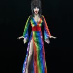 Cassandra Peterson Instagram – ANNOUNCEMENT! 🏳️‍🌈 🖤
➖
Elvira – Over the Rainbow Elvira 8” Clothed Figure 
➖
Celebrate Pride Month with Elvira, Mistress of the Dark! The devilishly delightful Cassandra Peterson has played the part of Elvira for more than 40 years with grace, humor and more than a little camp. NECA is proud to present this “Over the Rainbow” Elvira figure, celebrating the horror and queer icon in a never-before-seen, sparkling rainbow dress for your collection. With an original tailored fabric gown, glittery ruby red heels, and a yellow brick display base, she’s definitely not in Kansas anymore! This fully articulated 8-inch action figure features new faceplate technology with two interchangeable expressions and hands, including brand new ones that allow you to recreate Elvira’s signature pose! She comes with a book accessory of Peterson’s memoir, “Yours Cruelly, Elvira”, and a double-sided flag with 10 stickers to customize and show your unique pride! 
➖
Available now on thenecastore.com, and shipping to your favorite NECA retailer in June!
➖
#Elvira #MistressoftheDark #Pride #OvertheRainbow #CassandraPeterson #NECA  #actionfigure