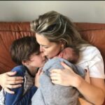 Chantal Janzen Instagram – 29 maart 2018. Om 07.30u belde ik naar de afdeling Verloskunde om te vragen hoe laat we mochten komen. We wisten dat ik op deze dag ingeleid zou worden. Om 11u stonden we op de gang daar, en zagen we dat de verloskamers namen van landen hadden. We stonden het dichtste bij ‘Mexico’, maar die wilden we niet want daar hebben we allebei iets tegen. Leg ik nog wel ‘s uit.
We kregen kamer Mexico. Er volgden weeënopwekkers door middel van een infuus en ze braken m’n vliezen. Rond 17u was er 4 centimeter ontsluiting. Gelukkig dacht ie toen nog niet ‘laat ik eens komen’ want dan had ik nooit meer kunnen fietsen, onder andere. Rond 17.40u zei ik tegen Marco dat ik zin had in bozen en frambessen. En de morfinepomp was nog niet eens aangesloten. En toen volgde een super uurtje: weeënstorm. Ik probeerde uit te tunen maar had op dat moment het gevoel alsof ik vanaf m’n maag en m’n hele onderkant in een doorgedraaide shredder vastzat. Ik zei dat de ruggenprik nu wel mocht komen. Op het moment dat de anesthesist middenin een van de pijnlijkste weeën zei ‘Je moet nu voorover bukken’ wilde ik op dat moment roepen ‘Sterf Jeroen’ maar ik zei OOOKEEEEEE en dat was beter. Voor Jeroen.
Om 22.30u werd er een kindje geboren wat niet huilde, waar ik van schrok en daarom riep ‘Gaat het goed met ‘m??’ Alles was ok. Hij had een glimlach op z’n gezicht. Achteraf dacht ik dat ik dit alleen zag door de morfinepomp, maar Marco zag het ook. ‘Als je zelf naar het toilet bent geweest mag je naar huis’, zei de verpleegkundige. Ik zei, met 4 verse hechtingen: ‘Nou ik weet één ding: ik ga nooit meer poepen’.
‘Jawel’, zei ze resoluut, ‘dat doe jij wel mevrouwtje’, zei ze met een heerlijk accent door haar Surinaamse roots.
Om 04.00u ‘s nachts kwamen we thuis en maakten we James, Isaa en Zion wakker, Essie via facetime. We legden Bobby naast James in bed en ik heb van geluk heel lang gehuild. Ik keek naar Bobby en dacht: Alles is goed.
Jouw oma, mijn moeder, noemt jou ‘De eeuwige glimlach’. En daar heeft ze gelijk in.
We houden met z’n allen zo van jou, onze kleine geluksbrenger. Je bent een zon in zoveel levens. En nu ben je 6. Ik verheug me op alles wat nog komen gaat met jou. ❤️🎈
