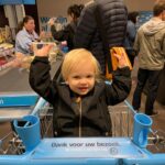 Chantal Janzen Instagram – 13.50u, onze lieve oude oppas appt me: ‘Jeetje, Manon is dood, wist je dat…?’
Ik wist ‘t niet.
Manon is geen familie. Geen vriendin, geen kennis. Maar toch zag ik haar vaak. Ze is een zogenaamde ‘zonnestraal op je dag’. Was. Want Manon is er dus niet meer. Twee maanden geleden zag ik haar voor het laatst, bij ‘mijn’ Albert Heijn. Manon was caissière, en een begrip daar. Ze maakte ‘n praatje met echt iedereen. Ik werd altijd begroet met een vrolijke ‘Heej lieve schat!’, met daarna altijd de vraag: ‘Hoe is ut met je ouders? Zeg je vader dat ie weer ‘s langs komt!’ Bobby en onze oude oppas waren fan van haar. Als Bob zag dat Manon er was gingen z’n handjes al de lucht in. “Zès alweer??’ zei Manon dan ook laatst toen ik vertelde dat hij bijna jarig is. ‘Ja Manon, de tijd vliegt’, zei ik cliché. ‘Niet piepe schat’, gewoon geniete!’ antwoordde ze streng.
Ieder mens heeft wel één of meerdere Manon’s in z’n leven: mensen die je niet ècht kent, waarvan je niet eens weet waar ze wonen of hoe ze van achteren heten. Maar het zijn mensen die je toch vaak, soms dagelijks, ziet en die jou met een praatje, hoe kort ook, altijd een fijn gevoel geven. Een kleine energiebom, een geluksinjectie, een zonnestraal. Wiens gesprek of woorden je op een grauwe dag kunnen opbeuren. Die hebben jullie vast allemaal toch? Ze maken je dag. De oudere portier bij het hotel waar ik sport die vaak verteld over zn moeder, of Joke van de bakker die net met pensioen is. De man van de bloemenstal die iedere keer zoveel verteld over slechts één bloem. De interieurverzorger die ik zó vaak tegenkom in theaters en studio’s waar ik werk, maar me iedere keer weer überblij begroet alsof we elkaar 20 jaar niet hebben gezien. Die ene moeder van school, de jongen van de koffietent die je iedere ochtend met de vrolijkste ogen een ‘fijne dahaag’ wenst. Bij deze een dankjewel aan alle Manon’s op deze wereld. En zeg het hen maar eens. Dat ze je dag maken. Want ik heb het haar nooit verteld, helaas. Jullie zijn de kleurenspikkels op een softijs.
Rust zacht lief mens. Dank voor het jarenlang maken van ieders dag daar❤️
‘Niet piepe, gewoon geniete’.
Foto @hetparool Lees hier ook het mooie stuk over Manon.