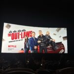 Chloe Bridges Instagram - Some pictures from the Out-laws premiere which is ON NETFLIX TODAY. This is a special one - adam started developing it in 2016, got incredible producing partners in @thatallencovert @adamsandler & happy madison, and then this incredible cast @nina @piercebrosnanofficial @michael_rooker @poornagraphy @comedianlilrel etc.. plus the New York Times said adam was finally funny and I know he’s been looking forward to that. Proud of you @adamdevine #theoutlaws @netflix