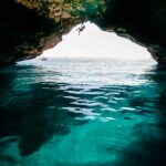 Chris Burkard Instagram - Mallorca, Spain. 2018 Shallow enough to clearly see the sandy bottom.. but deep enough to make the fall safe. A magical element of the Balearic Islands - home to some of the most stunning deep water soloing & cliff jumping I’ve seen to date. This nameless cave route was never completed, Chris fell from the last hold. A couple hundred feet of monkey swinging from 3 dimensional roof holds made this particular line easily the longest deep water solo @chris_sharma attempted that day. By far - the best part was watching him fully excited to try this route like a kid nearly jumping off the boat…