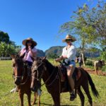 Chrissie Fit Instagram - Who would’ve pegged me as a guajira? Los paisajes de Cuba son una maravilla. The Cuban countryside is unreal. I recommend you go there and buy tobacco directly from the farmers. They are forced to give 90% of their crops to the government and only have 10% to sell themselves. It’s more authentic this way and you’re helping the farmer, who takes so much pride in growing their tobacco, fruits, veggies, and coffee. Btw, I did not know how to smoke a cigar. At the risk of losing my Cuban card, I will post in my stories 😅 #Cuba #Vinales #CuevaDelIndio #palenquedeloscimarrones #cubancountryside #ReturnToMyRoots #CubanHeritage #Cuban #Guajiro #Guajira