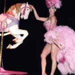 Dita Von Teese Instagram – The Carousel Horse ✨🎠✨
When @catherinedlish and I first debuted this act in 2001, as the new wave of burlesque was underway, it blew expectations among audiences and fellow entertainers. The top hat. The costume. The #carousel horse complete with shiny brass pole. Everything blindingly and colorfully twinkled with @swarovski ✨
Catherine’s costume was the most over the top she had done at the time. In my 2002 #Playboy cover story, I posed in my full “Carousel” act regalia, from plume to #pointe shoes, perched atop the twee horse. Alas, that #bedazzled beast went missing a few years later and we had to remake it. 
For Dita Las Vegas, three of the four jeweled horses now in my “stable” appear, side straddled by Von Teese Dancers in Jubilee archival costumes. 
🌟Dita Las Vegas has added even more shows! 🌟
March 27, 28, 29, 30
April 3, 4, 5, 6
April 10, 11, 12, 13
April 17, 18, 19, 20
April 24, 25, 26, 27
May 16, 17, 18
May 21, 23, 24, 25
May 29, 30, 31, June 1
June 5, 6, 7, 8
June 12, 13, 14, 15
Ticketmaster.com/ditavegas
