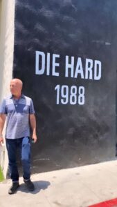 Emma Heming Instagram - Back in 2018 (when these videos and pictures were taken) we took Mabel and Evelyn to the Fox lot to peek at the archives as well as see the larger-than-life mural of their dad. This mural was unveiled in front of Bruce back in 2013 to commemorate Die Hard’s 25th anniversary. Today marks Die Hard’s 35th anniversary when it hit the screens and the rest is history. What Bruce has been able to accomplish in his career will never be lost on us. We are so proud of him 🤍