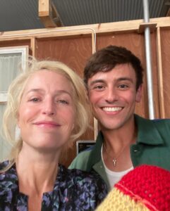 Gillian Anderson Instagram - Wanted to say a huge huge thank you to the darling @tomdaley for knitting this fantastic jumper (and crocheted willy 🌈) for me to wear for our final season of @sexeducation! 🧶🍆 Together we raised just over £12k for @mindcharity, which will be divided amongst 8 local Minds who work with LGBTIQA communities. Thank you for your stellar knitting skills Tom and for coming to visit me on set! Swipe to the end to see the post that started it all (in 2021 🤯)