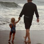 Gina Carano Instagram - My Papa Jack loved taking us to the ocean. He taught us how to play on the beach, boogie board, build sand castles, wear matching shirts, play games and at the end of the day BBQ ribs and stand around the camp fire singing oldies and cooking marshmallows. On other days he’d take us out on the sail boat, learning how to catch the wind, work together, pray the boat doesn’t flip over ☺️, work through the anxiety of docking and respect other boats on the water. Im amazed how many life lessons my Papa was teaching us just by taking us to the beach. How you interact with the ocean tells you a lot about how you interact with life. You either fear the storm and swim against the current or learn how to respect it and ride the waves. The combination of a great Papa and the ocean creates one of life’s greatest lessons and unforgettable memories. I am so grateful for him, today was his birthday. ❤️ -picture is of my lil sis and Papa. #myheart