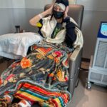 Grace Helbig Instagram – Scenes from chemo round 5! We’re officially 5/6th of the way through chemo!!! I can’t even process that right now, it’s all been so surreal. I brought this hat gifted to me by a friend of @mametown’s for a lil photo shoot. (If you listen to TMGW you know!) @elliottmorgan thought it was maybe “too dark” of a joke. Maybe he’s right, but I’ve lost my baseline for what’s normal or appropriate or “real life” at the moment so we’re just having fun! 5 infusions down! The adorable horrors of recovery await but we’re fucking doing it! 💪🏻🙃 #aintdeadyet