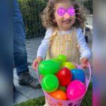 Iliza Shlesinger Instagram - We are Jewish but Sierra’s LA Grandma isn’t which means she gets Easter (and an Easter basket! I’m so jealous 🤍) and we all get Christmas. We filled eggs with Easter “candy” like… raisins and cashews and dried peaches and she had the best time. We did the neighborhood egg hunt too but she didn’t eat the chocolate because Mommy, who never lies, told her it was too spicy. Highlight for me was her holding this little blue bunny so delicately like it was a baby. Nothing will beat last year’s Easter outfit (last slide) but this one came close. 🐣🐰