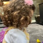 Iliza Shlesinger Instagram - We are Jewish but Sierra’s LA Grandma isn’t which means she gets Easter (and an Easter basket! I’m so jealous 🤍) and we all get Christmas. We filled eggs with Easter “candy” like… raisins and cashews and dried peaches and she had the best time. We did the neighborhood egg hunt too but she didn’t eat the chocolate because Mommy, who never lies, told her it was too spicy. Highlight for me was her holding this little blue bunny so delicately like it was a baby. Nothing will beat last year’s Easter outfit (last slide) but this one came close. 🐣🐰
