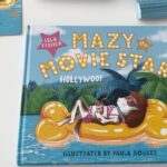 Isla Fisher Instagram - So fun signing for my new picture book Mazy the Movie Star with the talented Paula Bowles 🌼 Mazy lives in Hollywoof and has her fur fluffed twice a day. While other dogs chase sticks at the park, Mazy chases her acting dreams. Then one morning Mazy’s agent delivers bad news. Hollywoof has changed and there are no jobs for Mazy anymore. Can Mazy embrace what it is that makes her special and find her perfect role? @paulabowles_illustrator @welbeckkids @welbecksyd #MazytheMovieStar #AmazingMazy #Hollywoof #ChildrensBooks #PictureBooks #DogsOfInstagram The courageous tale of what it means to be true to yourself is published in the UK by Welbeck Flame on 29 September 2022 and on 5 October 2022 in Australia and New Zealand. Available widely. For pre-order details please see my Linktr.ee including in the UK from @Waterstones and in ANZ from @booktopiabooks.