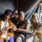 Lashana Lynch Instagram - Celebrating International Women’s Day honoring the one and only Mrs Rita Marley. This woman right here is beyond words. I’ll be telling my children and their children about getting to know her as a spirit and an icon in this lifetime with the biggest grin and the proudest heart. If you don’t yet know her story and enjoyed her presence in @onelovemovie, please read about her, listen to her words and her music and feel the impact she’s had on the Caribbean, Africa and many around the world. Thank you, @officialritamarley, for everything that you are and will continue to be. One love ✊🏾💛✨