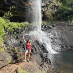 Laura Felpin Instagram - J’étais partie à l’ile Maurice après LA grande rupture.Je venais de regarder Mange Prie Aime, et je n’étais pas indifférente à l’idée de trouver Javier Bardem en bord de mer. Quand je suis arrivée à l’hôtel, j’ai compris que c’était un endroit spécialisé dans les lunes de miel. Interdit aux enfants. Que des adultes consentant de se bouffer la gueule H24 dans une ancienne demeure d’époque datant de la colonisation. Zéro respect pour les anciens esclaves, et pour moi donc. Je l’ai pris très personnellement. Sur mon lit, il y avait deux serviettes en forme de cygnes qui formaient un coeur des pétales de roses, un grand classique de l’hôtellerie de blanc. C’est là bas que j’ai purgé. Mais après mon sixième enveloppement au rhassoul plus finition gommage quand il n’y avait définitivement plus rien a gratter de moi, j’ai décidé de sortir de ma zone de confort, en réservant une randonnée: les 7 cascades. J’allais rencontrer des gens et on se parlerait sur WhatsApp pour se revoir à Port Louis. Parce que maintenant ma vie était ici. Je porterais du lin et je pratiquerais le tantrisme. Mais quand je suis arrivée, j’étais la seule a avoir réservé et la seule chose que le guide m’a dit c’est : vous n’êtes pas bien habillée pour l’activité, puis il m’a demandé de ne pas parler pour respecter la forêt. Pendant 4heures. Ceux qui me connaissent savent.Il aurait pu me demander de mettre mes doigts dans un toaster, mais 4h sans parler. Alors j’ai pensé. J’ai pensé qu’il faudrait trouver un signe, entre ex, comme les motards quand ils se croisent, pour se dire qu’on se re-connait, même 10 ans après. Un truc pour dire : je te sais. Et puis j’ai croisé un groupe de françaises. Pour elles, j’étais Annick en randonnée, y’avait pas plus cliché. On a fait des photos. Le guide m’a ensuite demandé de poser devant tous les points clefs de la randonné, sur le site ça lui ferait de la pub. Il m’a demandé de lever les bras, et d’avoir l’air je cite « mieux heureuse ». J’ai pleuré, on a continué à marcher. Si vous êtes dans votre grande rupture : je vous fait cadeau de ces photos, ça m’a mis longtemps mais aujourd’hui ce sont mes préférées. C’est vrai que j’étais mal habillée.