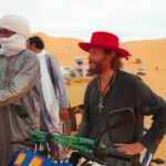 Lorenzo Cherubini Instagram - un anno fa oggi ero ad #agadez in Niger dove sembrava si fosse aperta una fase democratica importante per quella regione bellissima e inguaiata. Ero lì per la musica invitato da @bombino.official al festival de l’Aïr dove ho vissuto giorni indimenticabili nel cuore del Tenerè sahariano. Fantastico. In quell’occasione @ekoguitars_official è riuscita a donare un container di strumenti musicali e attrezzatura per i giovani di Agadez e Niamey. Adesso nessuno sa cosa sta succedendo in quell’area, dopo il colpo di stato militare le notizie non arrivano. Il ricordo di quei giorni e il desiderio di tornare da quelle parti è sempre vivo (perché gli “scambi culturali” ,nonostante l’epoca cinica e disincantata che attraversiamo, sono sempre belli e costruiscono pace e progresso oltre che musica pazzesca). Se vi va su @raiplay_official c’è un filmetto diretto da @giacomotriglia che racconta quel viaggio, si chiama Sahara Jam 🐪 @musicalista_produzioni @tinariwen