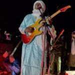 Lorenzo Cherubini Instagram - un anno fa oggi ero ad #agadez in Niger dove sembrava si fosse aperta una fase democratica importante per quella regione bellissima e inguaiata. Ero lì per la musica invitato da @bombino.official al festival de l’Aïr dove ho vissuto giorni indimenticabili nel cuore del Tenerè sahariano. Fantastico. In quell’occasione @ekoguitars_official è riuscita a donare un container di strumenti musicali e attrezzatura per i giovani di Agadez e Niamey. Adesso nessuno sa cosa sta succedendo in quell’area, dopo il colpo di stato militare le notizie non arrivano. Il ricordo di quei giorni e il desiderio di tornare da quelle parti è sempre vivo (perché gli “scambi culturali” ,nonostante l’epoca cinica e disincantata che attraversiamo, sono sempre belli e costruiscono pace e progresso oltre che musica pazzesca). Se vi va su @raiplay_official c’è un filmetto diretto da @giacomotriglia che racconta quel viaggio, si chiama Sahara Jam 🐪 @musicalista_produzioni @tinariwen
