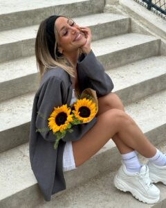 Mélanie Orlenko Instagram - @prettylittlething * Débardeur long en maille pointelle blanche détail noeud * Micro jupe taille basse en pointelle blanche détail noeud * Blazer très oversize gris anthracite * Chaussettes basiques blanches * Mini créoles fines torsadées plaqué or * Bandeau large en jersey noir #sponsorisé @sublimetalents