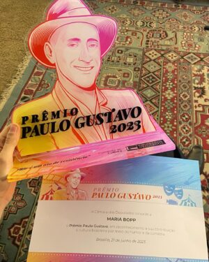 Maria Bopp Instagram - Hoje eu vim até Brasília receber o meu Prêmio Paulo Gustavo, homenagem criada pela Comissão de Cultura da Câmara dos Deputados a artistas que contribuíram pra cultura brasileira através da comédia e humor 🥹♥️ Fiquei muito feliz de ter sido escolhida logo na primeira edição! Não poderia estar mais honrada de ter sido indicada pela gigante deputada @jandira_feghali, responsável pela criação das Leis Paulo Gustavo e Aldir Blanc e cuja luta incansável pela cultura me inspira e tranquiliza. Hoje me senti muito realizada e reconhecida por todo tempo e energia que investi na Blogueirinha do Fim do Mundo, personagem que criei pra gente rir em uma época que o Brasil não tinha a menor graça. Aliviada de finalmente termos virado essa página (e com mais um capítulo importante a se desenrolar amanhã, com o capeta se tornando inelegível, se tudo der certo!🍀). Obrigada a todos os deputados que votaram em mim! Obrigada a todo mundo que acompanha e apoia meu trabalho. Viva nossa cultura, o MinC, a nossa arte e humor. Viva Paulo Gustavo e seu legado gigantesco. Hoje vou dormir feliz ♥️