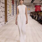 Maria Grazia Chiuri Instagram – With their ability to tame and transform textiles, shape silhouettes and control volumes, pleating and other forms of fabric manipulation play an important role throughout the new #DiorCouture Spring-Summer 2024 collection by @MariaGraziaChiuri. A white crêpe column exemplifies this type of #DiorSavoirFaire with its rows of precise pleats smocked to secure the positioning of the neckline and waist, while another draped dress is ingeniously gathered into a basketweave panel at the front. In red moiré faille, a pleated full skirt is paired with an update on the #DiorBarJacket to reinvent the original and peerless New Look icon.