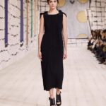 Maria Grazia Chiuri Instagram – With their ability to tame and transform textiles, shape silhouettes and control volumes, pleating and other forms of fabric manipulation play an important role throughout the new #DiorCouture Spring-Summer 2024 collection by @MariaGraziaChiuri. A white crêpe column exemplifies this type of #DiorSavoirFaire with its rows of precise pleats smocked to secure the positioning of the neckline and waist, while another draped dress is ingeniously gathered into a basketweave panel at the front. In red moiré faille, a pleated full skirt is paired with an update on the #DiorBarJacket to reinvent the original and peerless New Look icon.