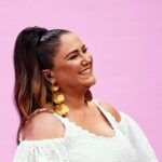 Maria Rita Instagram - Nação bacanuda, que 2024 seja um ano incrível e com muitos shows da patroa! Por aí, que música da Maria vocês já ouviram este ano? #EMR #PraTodosVerem Maria Rita sorri de perfil, vestida de branco e com um penteado de rabo de cavalo em um fundo rosa. Foto: @betojpeg @Wtliveoficial @_mediak