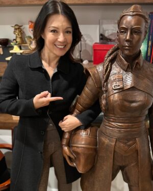 Ming-Na Wen Instagram - Like my twin?😂😂

Okay. Why do I have a LIFE-SIZE bronze statue of me as Fennec Shand? 

Well, my amazing husband started the process last April of having one made to celebrate my birthday.  It was carved from clay from just a photo as reference. The artistry and accuracy is remarkable. Several revisions took place. (Thank you, @mitchelwuphotography & @jenchiwu for your input.🥰) This was all done in secrecy. 

Unfortunately, it didn't arrive in time for my birthday last November. It just arrived last week. When we had a couples night with some of our dearest friends we've known for over 20 years, Eric unveiled it. What a tremendous surprise! We were all in awe!

He knows how much #starwars means to me; how being Fennec has been a childhood's dream come true for me. So he wanted to celebrate my birthday with something unique and BIG! He succeeded!!

At first, I was utterly astounded and amused. I also thought he was crazy! Where the hell were we going to put it? She couldn't be outside scaring people!

Once we moved her inside,  she actually fits great in our media room. She's home!
I love bronzed Fennec more and more, just like my love for this marvelous man. She's a daily reminder of how lucky I am to have such a thoughtful and loving husband. He's the best!  Thank you, babe! I love you, always. 
❤️🥰
#thisistheway #fennecshand #themandalorian #thebookofbobafett #starwars