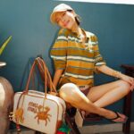 Molly Chiang Instagram - MiuMiu girl in Bali ✨💚🧡🖤 #miumiu @miumiu - 在峇里島買到的戰利品讓我心情整個變彩色起來 心情快樂到跟今天的穿搭一樣繽紛樂😂 就是我掛在包包上的螃蟹 章魚編織娃娃掛飾🥹❤️ 這個掛飾是我在 @Amankila 禮品店買到的 當時看到被這個可愛到心臟漏一拍（好浮誇） 太有趣太可愛的掛飾了！！！ 而且掛在這顆MiuMiu包上面顏色有夠配耶？ 毫無違和🤣 你們說是不是超可愛！ 你們喜歡螃蟹還是章魚的？ 另一個超愛的戰利品 就是脖子跟手上的小花項鍊跟手鍊 這個就是峇里島市集的飾品攤販買到的 大家如果去峇里島有逛一些市集 可以都看看有沒有 還有很多顏色的 我自己買了白色跟薄荷綠💚☺️ 在峇里島還是要來點色彩的搭配🥹 自己好喜歡這組照片的配色 吃早餐的時候看到這面藍色的牆壁就覺得應該很適合配我這套拍💙😍 喜歡這套嗎😙