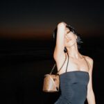 Molly Chiang Instagram - Bali‘s sunset magic 🌅❤️‍🔥 @louisvuitton #louisvuitton Just in case ✨ - 各位觀眾！！！ 不可能來峇里島度假又有大片吧（？） 不可能這組照片就是 @aaron77926 小安用我的徠卡Q3 閃燈、然後我再自己調色裁切後就產生這組照片吧🤣 #最後有影片幕後花絮 這次許願想要有一組峇里島夕陽後晚霞火燒雲的背景美照 加上想要幫 @louisvuitton 這顆港澳台限定販售的Just in case 包拍一組大片 昨天我們就去海邊等晚霞 然後小安就幫我拍到了🥹✨ 整個海邊明明一堆人 我們卻好像活在自己的兩人世界宇宙大拍特拍😂 「安莫組合」拍出來的成果照是不是也蠻美😳✨ 你們覺得如何？😛🖤❤️‍🔥 P.S. 拍到美照的我又在海邊大跳驚鴻舞 因為我這件外罩的袖子根本為了跳驚鴻舞而設計的吧（？） 想看驚鴻舞影片嗎（咦） 想看 1（明明就自己很想發死要問） Bags/ @louisvuitton Swimsuit/ @cosstores
