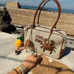 Molly Chiang Instagram - MiuMiu girl in Bali ✨💚🧡🖤 #miumiu @miumiu - 在峇里島買到的戰利品讓我心情整個變彩色起來 心情快樂到跟今天的穿搭一樣繽紛樂😂 就是我掛在包包上的螃蟹 章魚編織娃娃掛飾🥹❤️ 這個掛飾是我在 @Amankila 禮品店買到的 當時看到被這個可愛到心臟漏一拍（好浮誇） 太有趣太可愛的掛飾了！！！ 而且掛在這顆MiuMiu包上面顏色有夠配耶？ 毫無違和🤣 你們說是不是超可愛！ 你們喜歡螃蟹還是章魚的？ 另一個超愛的戰利品 就是脖子跟手上的小花項鍊跟手鍊 這個就是峇里島市集的飾品攤販買到的 大家如果去峇里島有逛一些市集 可以都看看有沒有 還有很多顏色的 我自己買了白色跟薄荷綠💚☺️ 在峇里島還是要來點色彩的搭配🥹 自己好喜歡這組照片的配色 吃早餐的時候看到這面藍色的牆壁就覺得應該很適合配我這套拍💙😍 喜歡這套嗎😙