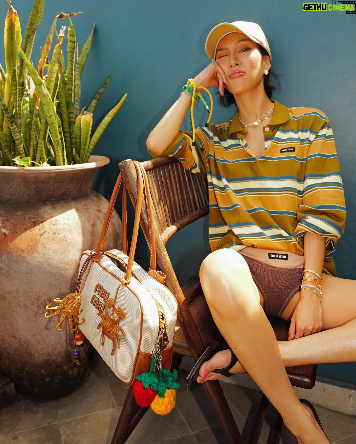 Molly Chiang Instagram - MiuMiu girl in Bali ✨💚🧡🖤 #miumiu @miumiu - 在峇里島買到的戰利品讓我心情整個變彩色起來 心情快樂到跟今天的穿搭一樣繽紛樂😂 就是我掛在包包上的螃蟹 章魚編織娃娃掛飾🥹❤️ 這個掛飾是我在 @Amankila 禮品店買到的 當時看到被這個可愛到心臟漏一拍(好浮誇) 太有趣太可愛的掛飾了!!! 而且掛在這顆MiuMiu包上面顏色有夠配耶? 毫無違和🤣 你們說是不是超可愛! 你們喜歡螃蟹還是章魚的? 另一個超愛的戰利品 就是脖子跟手上的小花項鍊跟手鍊 這個就是峇里島市集的飾品攤販買到的 大家如果去峇里島有逛一些市集 可以都看看有沒有 還有很多顏色的 我自己買了白色跟薄荷綠💚☺️ 在峇里島還是要來點色彩的搭配🥹 自己好喜歡這組照片的配色 吃早餐的時候看到這面藍色的牆壁就覺得應該很適合配我這套拍💙😍 喜歡這套嗎😙