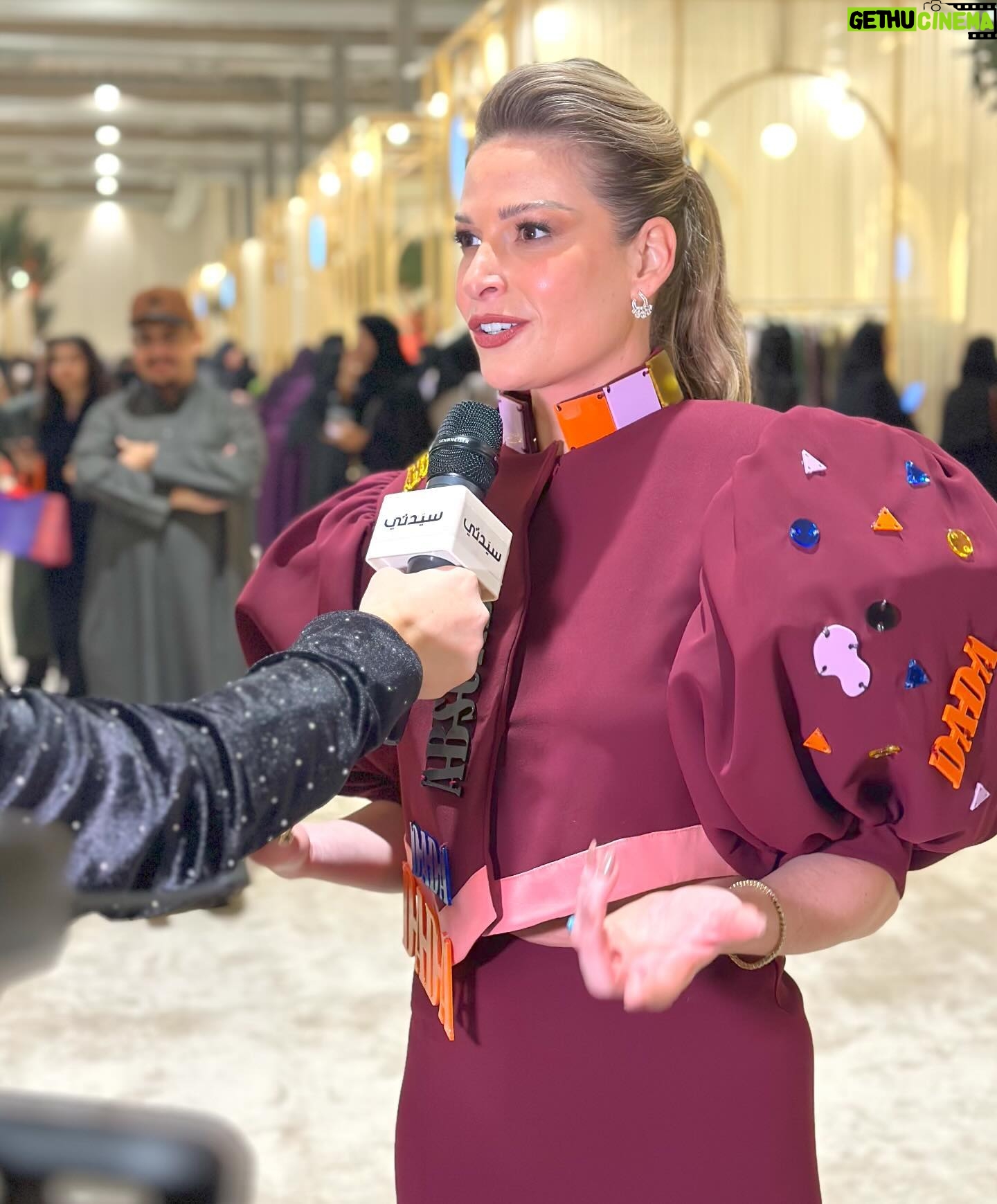 Pamela El Kik Instagram - من لحظة ما وصلت على مطار #الرياض #السعودية لأيّ مكان تواجدت في، انغمرت بِحُبّ شعبو والبسمة الحقيقية وحسن الضيّافة اللي ما إلا وصف👑 ممنونة ومشكورة لكل نقط الحُب 🇸🇦 #أنا_عربية ••• I decided to support a young talent from my country by wearing a full look from Nour Takieddine’s D2D collection. •A collection inspired by the Dada art movement, created as a reaction to the violence and absurdity of world war 1. In such hard times, I believe in the power of art as a great way to express our emotions, and rebel against the way our world functions today. •Nour Takieddine’s collection was a perfect fit for my way of thinking, and I really wanted to wear this look tonight that consists of an extravagant jacket, with a fully hand embroidered back illustration of Emmy Hennings. I saw a part of me in this woman, and that was an extra reason for me to pick this specific look. •Hennings was a bold artist, poet, and performer who fought so much for her thoughts and questioned a lot the societal norms. All the handwork on the back of this jacket started from a one line drawing technique done by Nour, representing an autoportrait of Emmy. •The look also consists of an asymmetric skirt that has a deconstructed waistline, and a curvy hem another way to rebel against what we think is ‘normal’, the outfit is embellished with plexy laser cut elements representing words and geometric shapes referencing Dadaist paintings and exploring new materials that are considered odd or weird applied on fabric. • to complete the look with these special heels with hand embroidered abstract faces inspired by DaDa collages and plexy embellishments ✨ @n.tbynour 🧡