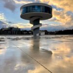 Paz Bascuñan Instagram - Avilés en 10 imágenes. En Avilés me nace sacar fotos a cielos, esquinas, momentos, reflejos… Hay algo en la luz de esta ciudad que hace que los colores vibren y eso atrapa. ¿Será la lluvia frecuente que hace que todo esté tan limpio y vivo? Avilés es una ciudad a escala humana. Cuando alguien muere ponen “esquelas” en las paredes avisándole a la comunidad que esa persona se ha ido. Viejos y jóvenes se detienen a leerlas, porque aunque son 80.000 habitantes, se relacionan como comunidad. Este viaje relámpago, en medio de la gira de teatro de #sosmamis, imaginé sería agotador, en cambio ha sido una inyección de energía. RESPIRAR. Y pienso en Santiago de Chile, el aire que respiro en mi ciudad. Los colores apagados por ese velo gris que lo cubre todo. Nuestra cordillera es preciosa … sí… una maravilla …cuando se ve. Lo más básico y sustancial: el aire que respiramos , es malo. ¿La culpa la tiene el valle y su mala ventilación? ¿las empresas? ¿las políticas de estado? ¿la sobrepoblación? ¿nuestros hábitos?… Mi vecino prende el carbón porque tiene derecho a parrillar… total … su contaminación no hará la diferencia. Yo llevo a mis niños al colegio en auto en vez de hacer turno con mi vecina…total … mi contaminación no hará la diferencia. ¿Qué será lo que finalmente haga la diferencia para que tengamos inviernos sin nuestr@s viej@s e hij@s enfermos? Dicen que los seres humanos nos acostumbramos a todo. Aún no me acostumbro. Quizá por eso saco tantas fotos en las ciudades donde cada inhalación es un regalo. #gracias #aviles #respirar #tomarconciencia #hacerladiferencia #comunidad #nuevoshábitos #urgencia