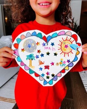 Rachel Hollis Instagram - Noah’s class was doing a “family Valentine” project. They sent home the special Valentine. We had ONE job… return a Valentine decorated by the whole family to school today. 

I swear I saved it. I swear it was just on the counter. 

But for one Billion dollars, I can’t tell you what happened to the special Valentine. We looked everywhere last night. 

Plan B… I drew a new special Valentine. I called in every member of the family, we colored it in, we each added a picture. Noah added LOTS of stickers. I don’t know if this is what the special family valentine project was supposed to be— whale shark riding the sun?? But this is how we do things around here! Our family will always be slightly messy and loud and colorful and definitely imperfect, but I love us. Also, I love how this turned out. 

PS- I know that tooth needs to come out guys, she’s wiggling it at her own pace 😅