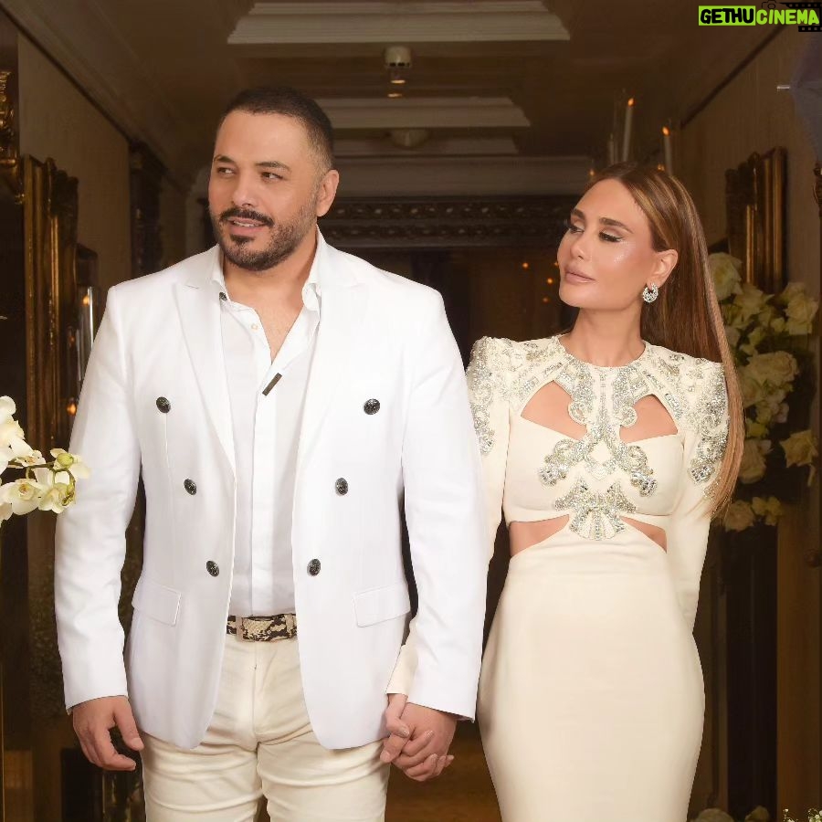 Ramy Ayash - 34.6K Likes - رامي عيّاش.. يتزوج مرة ثانية !
لينك الفيديو في البايو
لم تكن الذكرى السنوية العاشرة على زواج البوب ستار "رامي عيّاش" كسواها ، هو الذي يقدم دوماً تحف فنيّة استثنائية، حضرت هذه الليلة الحالمة ليتغنى رامي بأفكاره الخلاقة ويأخذنا معه الى عالمه بمشهدية قلّما يقال عنها ملكية بلمسات راقية.
رامي الذي أراد ان يخلد هذه الذكرى السعيدة مع محبيه، فاجىء زوجته مصممة الأزياء داليدا عياش بعد عشاء متواضع وخاص مع العائلة في فندق هيلتون حبتور بمناسبة عيد ميلادها الذي حوله الى حفل زفاف أدهش به داليدا والجميع .
وتكلل الحفل اطلالة ملكية لداليدا اختارها لها مصمم الازياء العالمي زهير مراد الغالي على قلب داليدا، بفستان ابيض تناسب تماماً مع هذه الليلة الحالمة كان بانتظارها في الجناح الملكي مع فريق عمل جاهز لتغيير الماكياج مع افون ابي حاتم والشعر مع وديع شليطا وفادي عواد .
وبتنسيق مع الماركة الأحب الى رامي وداليدا روسونيرو ميشال زغيب ، اختار رامي خاتم بتصميم خاص يقال انه من أجمل تصاميم الماركة العالمية وهو الحجر واللون الاحب على قلب داليدا الاميرالد مرصع بالألماس اشبه الى الخيال.
ولدى دخولك الى الصالة المزدانة بأنامل منسق الحفلات وليد باز "باز ايفينت "، تلفتك فخامة الديكور والورود التي تحيط بك كيفما نقّلتَ نظريك.. حيث انتظرهم الأصدقاء والأحباب والعائلة ليستقبلوا العرسان، ولم يكتف رامى عياش بذلك انما خصها بأغنية من اللهجة اللبنانية وهى "يا مراية بيتى" زخرفها بألق وجده وعشقه من ألحانه وكلمات الشاعر مازن غنام وتوزيع الكسندر ميساكيان.. واختتم الحفل بسهرة فنية مميزة مع محبيه الذين رفضوا إلا ان يشاركوه فرحته.