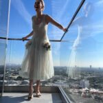 Rosamund Pike Instagram – Days of wine and roses. Long have I wished to wear a dress by @simonerocha_  This felt whimsical and witty and painterly for the @bafta tea party at the Maybourne Hotel which was on a terrace decorated with red roses! 

Thank you @leithclark for the joy, @kyleeheathhair for the beautiful bun @tamah_krinsky for the face magic. And @prosper_pr for it all.