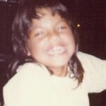 Sara Ramirez Instagram – Pic of Sara, at around 8 years old, wearing a light yellow shirt, a huge smile, and an early 80s mullet. 

Second pic is of 2 books; Sara’s extra flowery “This is the Story of” baby book open to the Baby’s Arrival page with birthday info, and the very serious looking Fathers Labor Coaching Log and Review Book because 1975. 

There is so much to say but I’m gonna keep it simple. You’re welcome.

Happy birthday to me! May this kid continue to feel and know that they are loved beyond their gender, they are valued beyond their productivity, and they will always be held and protected by this softening blossoming adult who may or may not be bringing their killer mullet back.