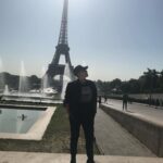 Sara Ramirez Instagram - That time I traveled with a good platonic friend 🎉 @thefreeactorvist 🎉who just got it (and still gets it) and there was mutual support and ease in co-creating a fucking GREAT time! Celebrating good platonic friendships because they matter too! 📷🎥: @thefreeactorvist . . . Image 1: Sara reclaiming Paris for themselves. They are facing the camera, sunglasses on, hands in pockets, standing in all black joggers, boots, jacket, black tshirt that reads “binaries are for computers” in black font over a square of white zeros and ones, ballcap that has “X=“ in white. Paris and the Eiffel Tower in the background, sunny clear sky. Image 2: Same everything except Sara’s head is turned to camera right. Video: Sara singing “You Oughta Know” by Alanis Morissette into a green lit mic at a red light district karaoke bar. Sara is wearing white joggers, a camo sweatshirt and same black ballcap with the “X=“ in white. Sara is FEELING IT. The bar is low lit in reds, purples, yellow and green, passersby in the background by the front door -some walking by and one just chilling watching from the cobblestone walkway outside.
