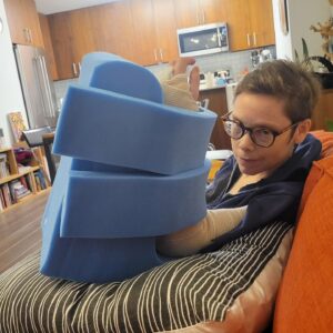 Abigail Savage Instagram - Back to square one and then some! Just had a three hour wrist surgery today. Pillow is the keep my arm in place while I elevate - we call it 'Bluey.' (in honor of a certain Australian cartoon Dog)